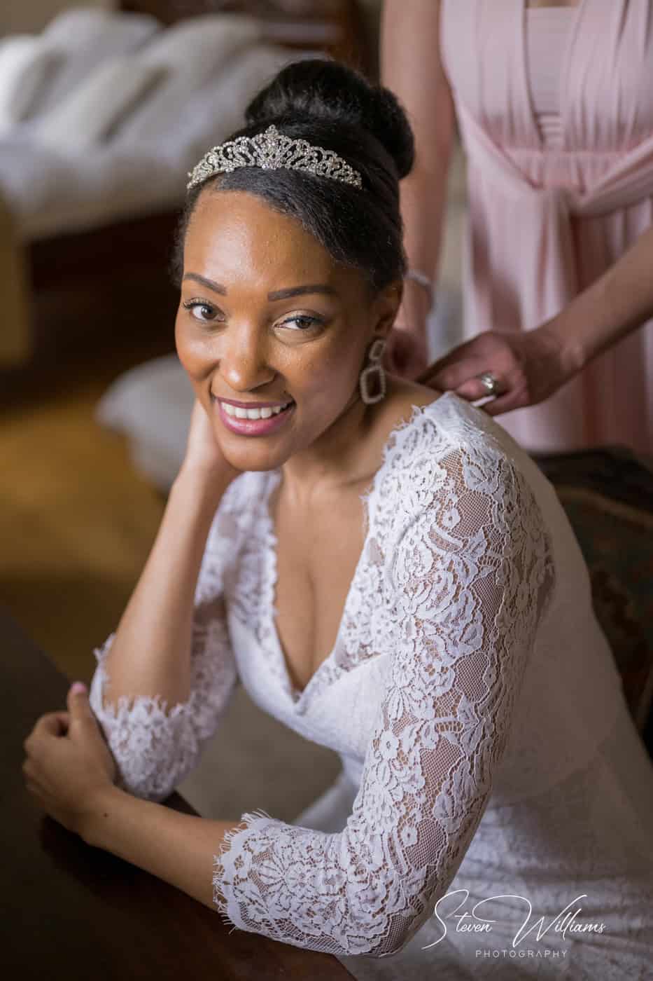 Bride smiling, tiara, lace wedding dress, preparations.