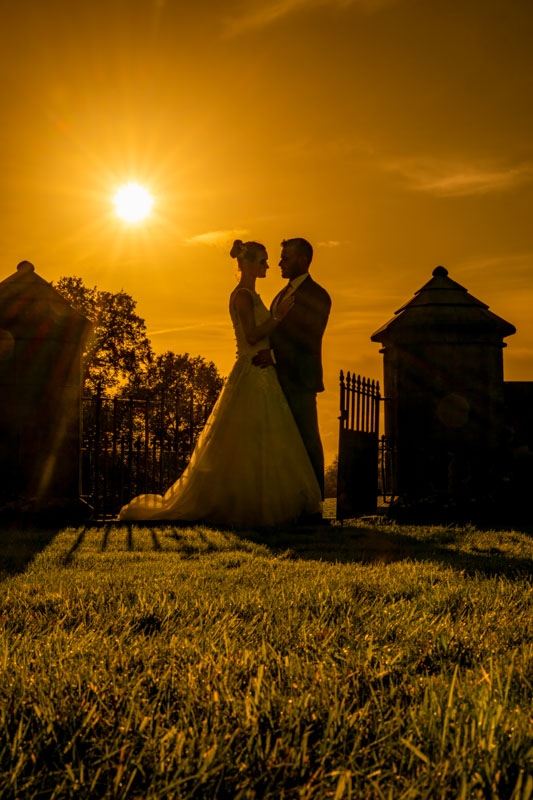 Couple silhouetted in sunset at wedding